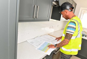 Customer Looking At Plans For New Kitchen