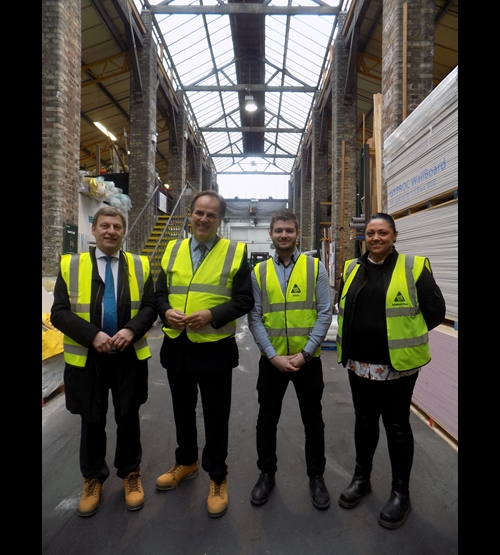 Four people dressed smartly wearing High vis jackets